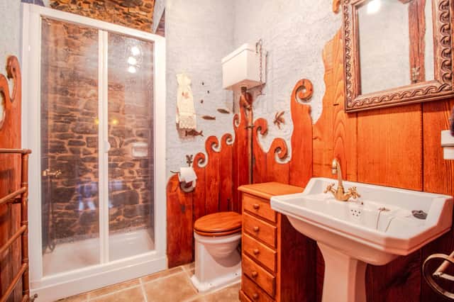 Baño con piedra y ducha de la casa rural