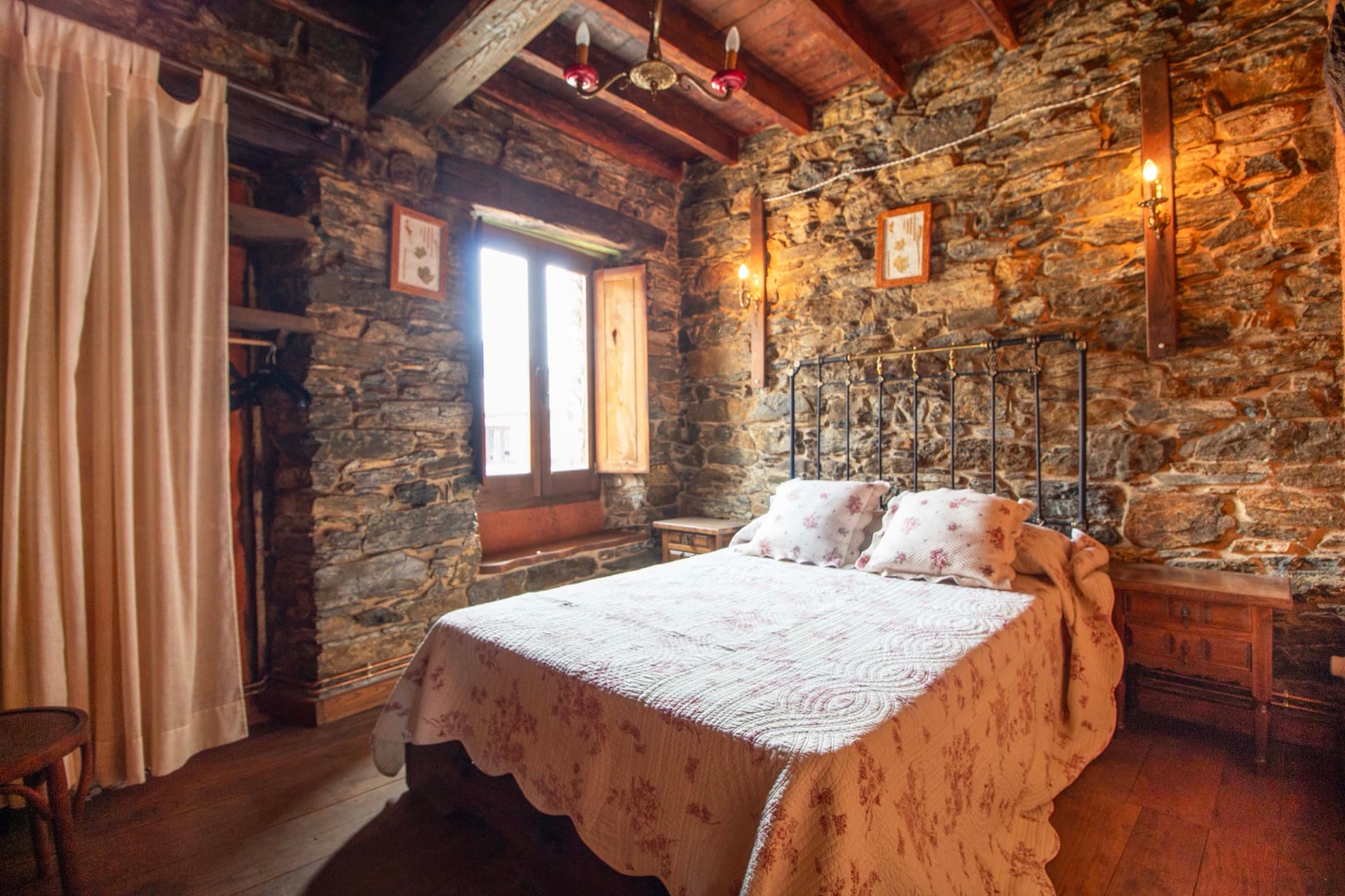 Dormitorio rústico con vigas y cabecero de madera